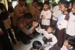 Kapolres Sukabumi, AKBP Maruly Pardede dan Istri saat bercengkrama dengan para siswa SDN 2 Pelabuhan Ratu Sukabumi. ( Jabar Memanggil/ Ist)
