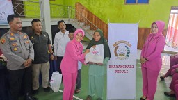 Ketua Bhayangkari Cabang Sumedang  Linda Joko Dwi Harsono, saat memberikan sembako gratis untuk warga  di Desa Tarikolot, dan Desa Cimanintin (ist) 
