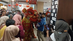 Salah seorang anak memberikan angpau di atraksi barongsai tahun baru imlek 2025 yang dilaksanakan mal plaza asia Sumedang. Sabtu (8//2025) 
