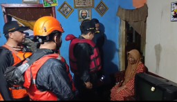 Bupati Sumedang Dony Ahmad Munir saat berbincang dengan salah seorang warga yang rumahnya terendam akibat luapan sungai Cimande. Jum'at (14/3/2025). 
