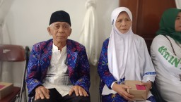 Pasangan lansia Qomar dan Istrinya Hasanah saat mengikuti bimbingan haji di gedung Islamic Center Sumedang. Rabu (23/4/2025). 

